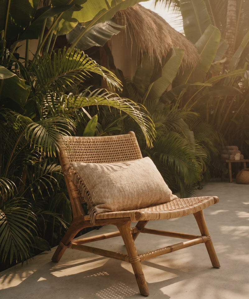coussin coton beige franges pose sur un fauteuil 