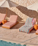 fouta rayee bleu et rose posee sur un transat