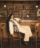 Femme qui porte un gilet léopard fourrure waro dans un salon