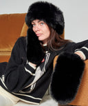 Détail des moufles en fausse fourrure noire, texture douce et finition premium