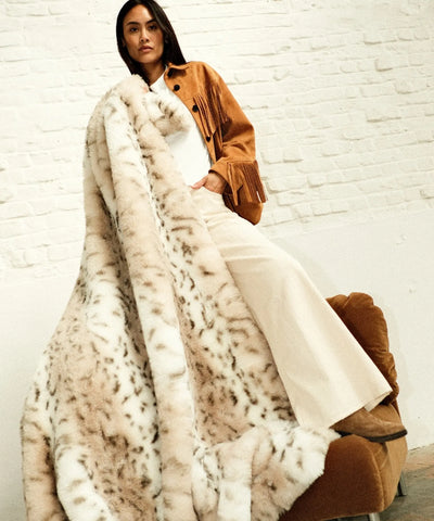 Plaid fausse fourrure Léopard des Neiges WARO en lookbook, plan large, style élégant et cosy.