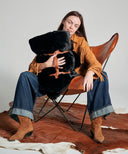 Plaid fausse fourrure panthère noire roulé avec attaches en cuir vegan pour rangement.