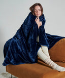Midnight-blue fleece blanket, soft and warm, worn on a sofa for an elegant cocooning moment.