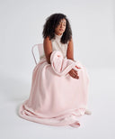 Plaid polaire cosy rose poudré waro sur les genoux d’une femme