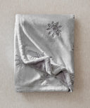 Folded grey snowflake fleece blanket with soft texture