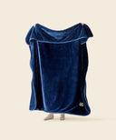 Plaid polaire cosy bleu nuit tendu par une personne 