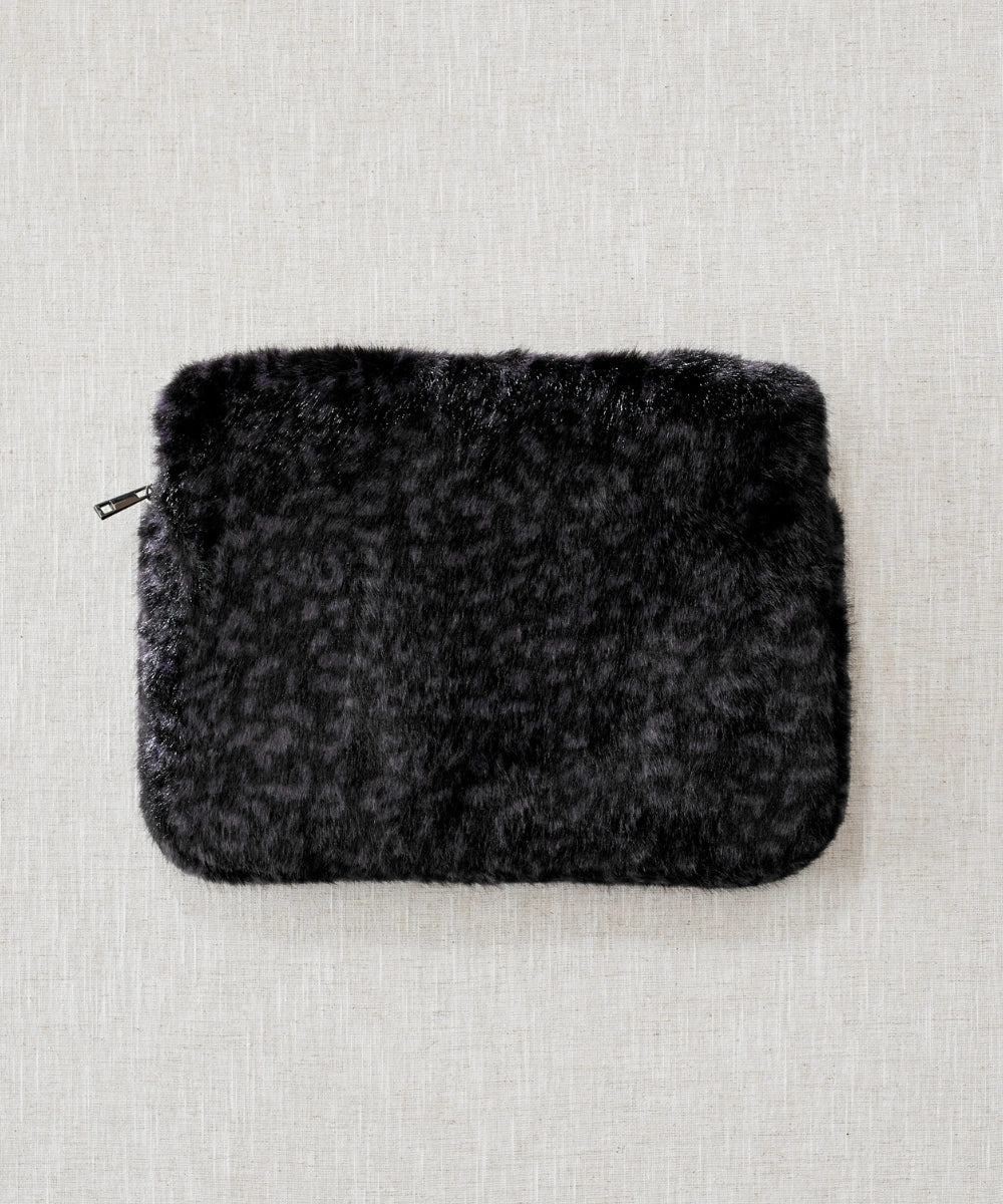 pochette ordinateur panthère noir waro posé à plat sur un fond beige 