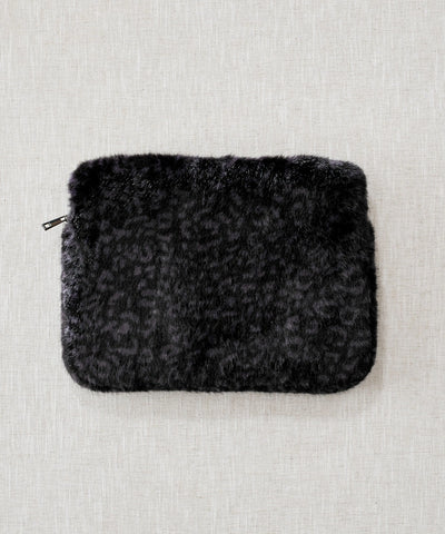pochette ordinateur panthère noir waro posé à plat sur un fond beige 