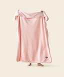 Plaid polaire cosy rose waro tendu par une  femme