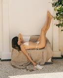 Fouta en coton beige WARO utilisée en plaid, moment de détente