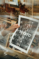 Document WARO tenu à la main devant un mur d’inspirations, illustrant le savoir-faire textile et l’ADN de la marque