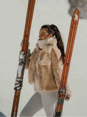 Veste courte Teddy Bear WARO en moumoute beige portée en montagne avec des skis.